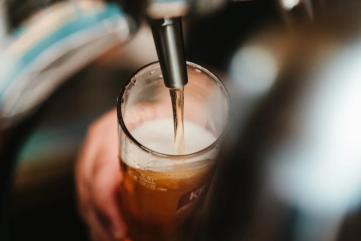Systematic Pale Ale in a glass with soft warm lighting and rustic brewery background