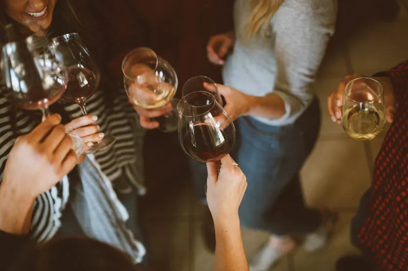 Guests raising glasses in a warm, modern taproom celebration with amber lighting